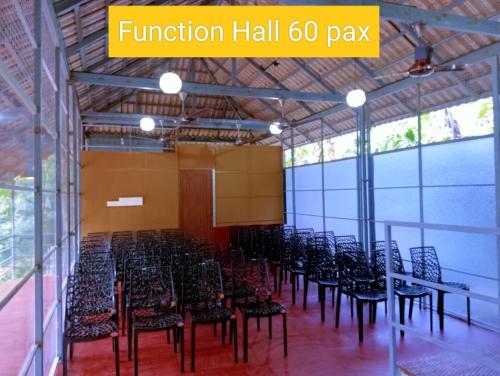 una stanza con un mucchio di sedie e tavoli di Forest and River Edge Resort a Kannur