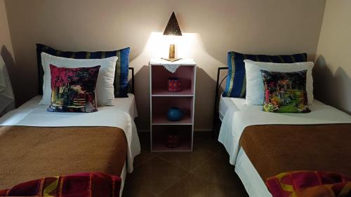 a room with two beds and a lamp on top at Chez Axia Tanger in Tangier