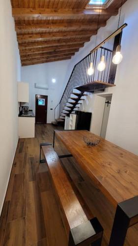 a living room with a wooden table and stairs at Casa 3 Meadas in Póvoa e Meadas