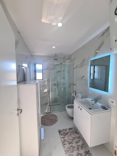 uma casa de banho com um chuveiro, um WC e um lavatório. em Elite1 5C em Saranda