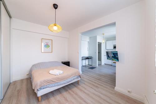 Dormitorio blanco con cama y pasillo en Centre ville Foirail APPART EVASION - Studio N°1, en Pau