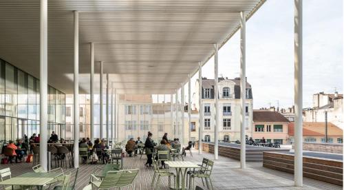- une vue sur un bâtiment avec des personnes assises à table dans l'établissement Centre ville Foirail APPART EVASION - Studio N°1, à Pau