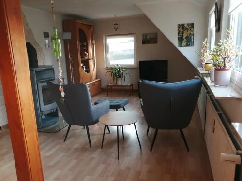 ein Wohnzimmer mit 3 Stühlen und einem Tisch in der Unterkunft Ferienwohnungen am Schwanenteich in Mühlhausen