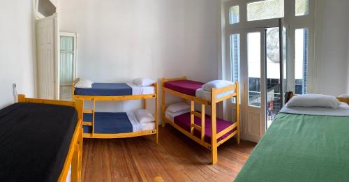 a room with three bunk beds and a window at MiBAQ Hostel in Buenos Aires