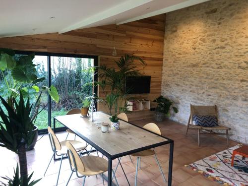 une salle à manger avec une table et des chaises dans l'établissement Uluwatu - cottage cosy, à Saint-Laurent-de-Médoc