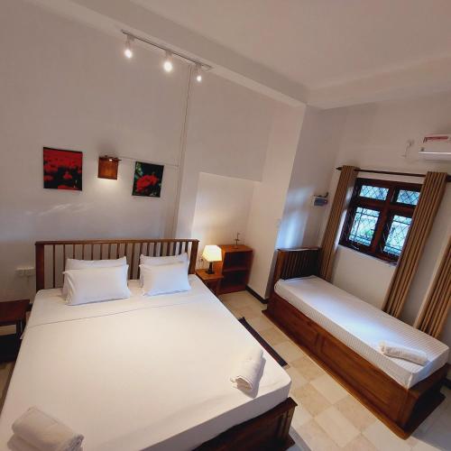 a bedroom with two beds and a window at Golden Villa Kandy in Kandy