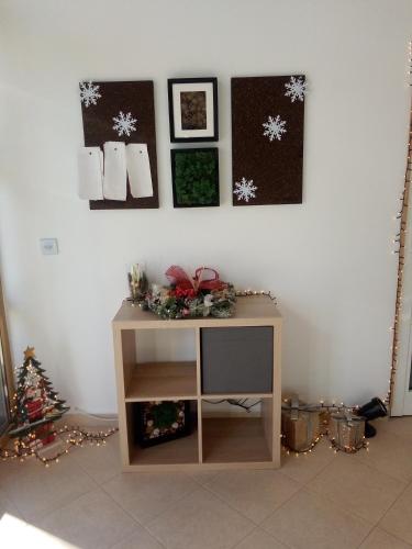 Cette chambre dispose d'une télévision et de décorations de Noël sur un mur. dans l'établissement Синьо небе, à Bansko