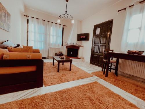a living room with a couch and a piano at Muses Apartments in Pisoderi