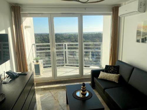 salon z kanapą i dużym oknem w obiekcie Widok na Morze Porta Mare - Apartament 339 w Dziwnówku