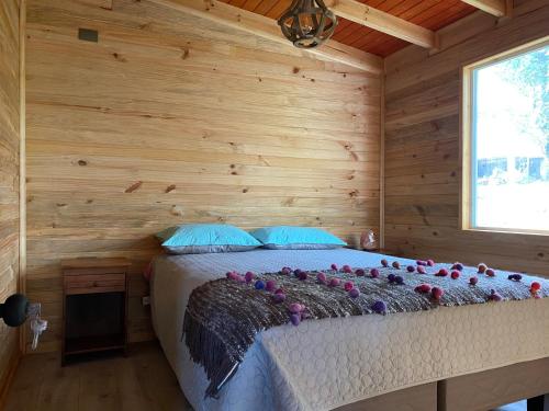 1 dormitorio con 1 cama en una cabaña de madera en Cabañas Aliwen isla Quehui, en Castro