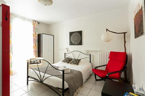 ein Schlafzimmer mit einem Bett und einem roten Stuhl in der Unterkunft La Clé d'Or in Servian