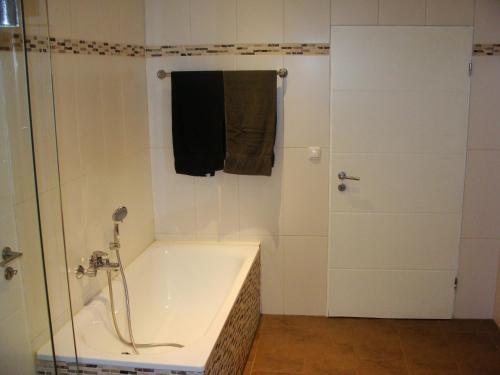 ein weißes Bad mit einer Badewanne und einer Dusche in der Unterkunft Cottage Hühnerstall in Zülpich