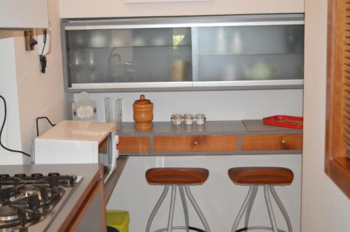 a kitchen with two bar stools in front of a window at DOMUS B Corso Francia apartment in Rome