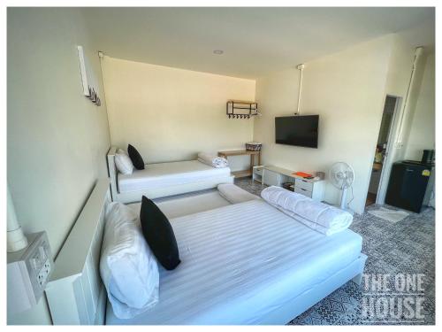 a hotel room with a bed and a tv at The One House in Nan