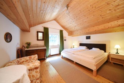 duża sypialnia z 2 łóżkami i drewnianym sufitem w obiekcie Castel Campan w mieście Bressanone