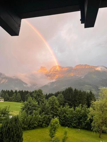 a rainbow in the sky with mountains in the background at Berghaus Gesäuse Pension in Weng im Gesäuse