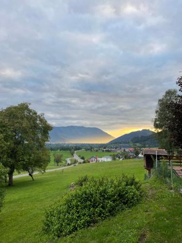 a view of a field with mountains in the distance at Berghaus Gesäuse Pension in Weng im Gesäuse