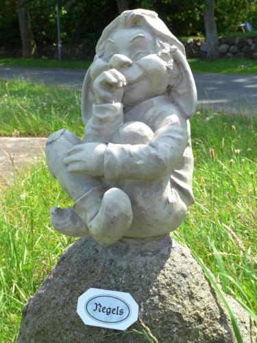 a statue of a child sitting on a rock at Gasthaus Knudsen in Utersum