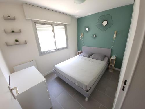 ein kleines Schlafzimmer mit einem Bett und einem Fenster in der Unterkunft T2 plage de sable à 300m+ parking gratuit in Bandol