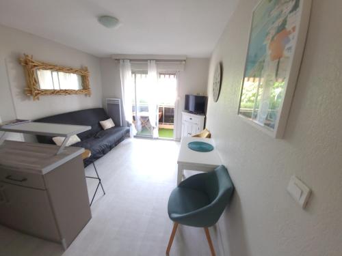ein kleines Wohnzimmer mit einem Sofa und einem Tisch in der Unterkunft T2 plage de sable à 300m+ parking gratuit in Bandol