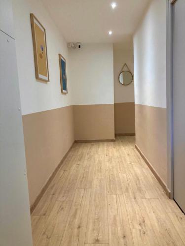 an empty room with a wooden floor and striped walls at Le Pearl Appartement de charme en bord rivière in Collobrières