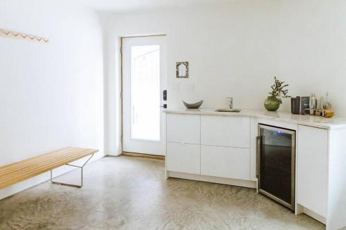 a kitchen with white cabinets and a bench in it at Okt Häus in Nordegg