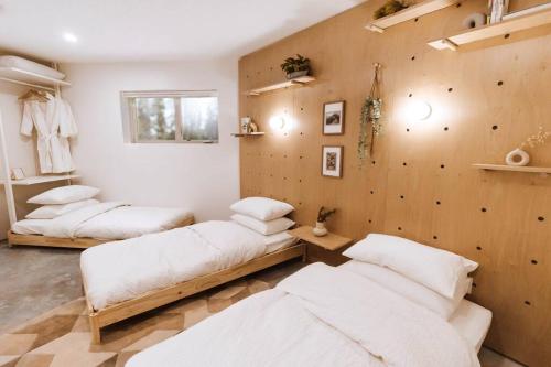 a room with three beds and a wall with wooden panels at Okt Häus in Nordegg