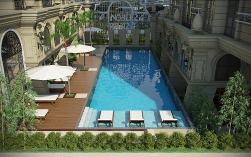 a swimming pool with chairs and umbrellas next to a building at Nahas Condo Hotel in Manila