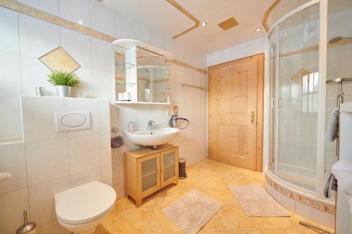 a bathroom with a sink and a toilet and a shower at Haus Moosmann am Sonnenplatz in Kössen