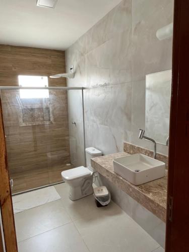 ein Bad mit einem WC, einem Waschbecken und einer Dusche in der Unterkunft Casa inteira em C Vermelha in Porto Seguro