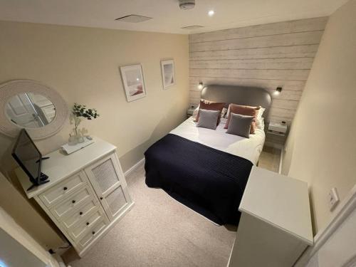a bedroom with a large bed and a mirror at The Little Snug in St Ives in St Ives