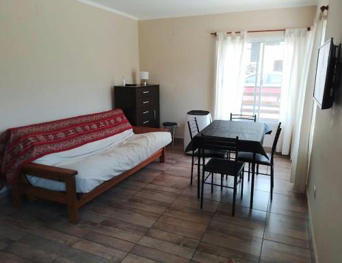 a bedroom with a bed and a table with chairs at Cabañas La Fortaleza in La Caldera