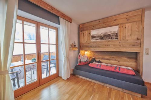 ein Schlafzimmer mit einem Bett und einem großen Fenster in der Unterkunft Haus Moosmann am Sonnenplatz in Kössen