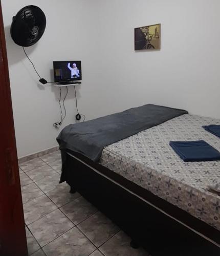 1 dormitorio con 1 cama y TV en la pared en Apto Araujo Macae en Macaé