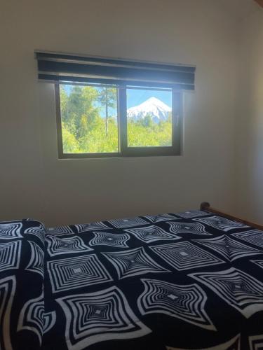 a bedroom with a bed with a view of a mountain at Casa peumayen in Puerto Varas