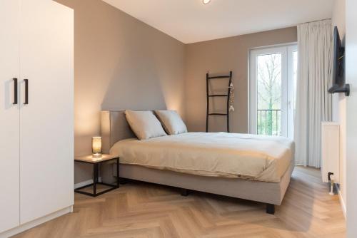 een slaapkamer met een groot bed en een raam bij Appartement in Marina Kamperland in Kamperland