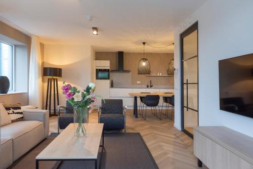 a living room with a vase of flowers on a table at Appartement in Marina Kamperland in Kamperland
