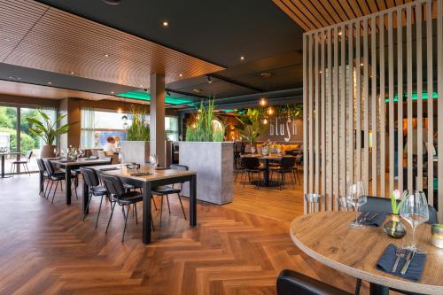 a restaurant with wooden floors and tables and chairs at Appartement in Marina Kamperland in Kamperland