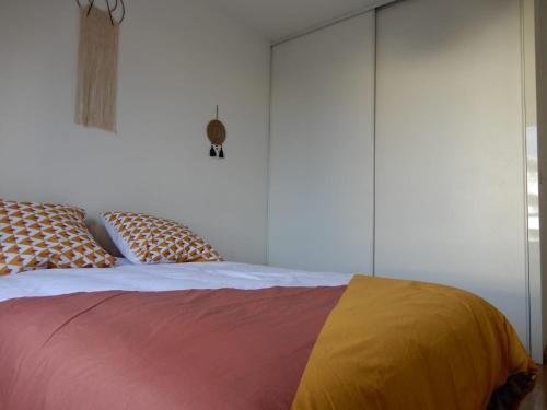 a bedroom with a bed with a colorful blanket on it at Bienvenue au Cocon d'Alyssa in Langon