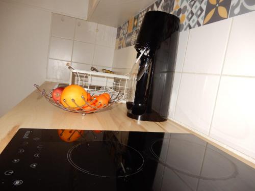 a bowl of fruit on a counter in a kitchen at Bienvenue au Cocon d'Alyssa in Langon
