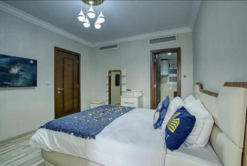 a bedroom with a large white bed with blue pillows at LOFTS by Elegant Hospitality in Cairo