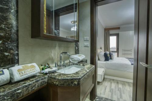 a bathroom with a sink and a bed in a room at Lofts by Elegant Hospitality in Cairo