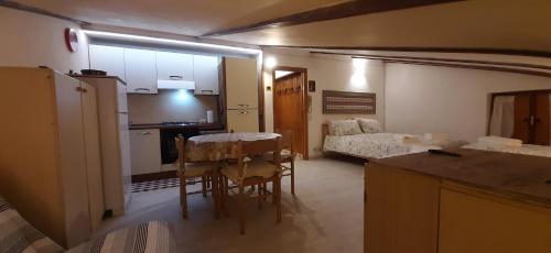 a kitchen and a living room with a table and a bed at Casetta all'Abetone Jacopo e Sabrina in Abetone