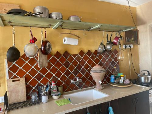 uma cozinha com um lavatório e algumas panelas e frigideiras em The Flying Carpet - Crater Camel Mount View em Mitzpe Ramon