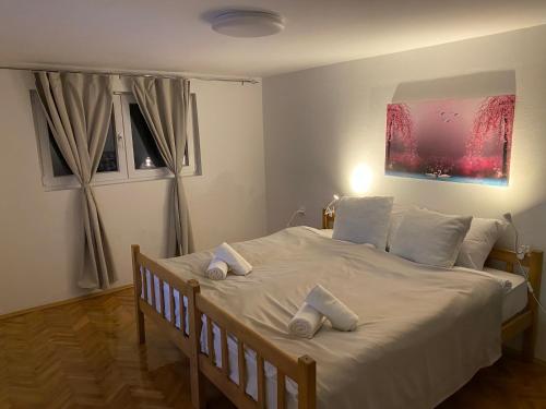 a bedroom with a large white bed with towels on it at FIA House in Skopje