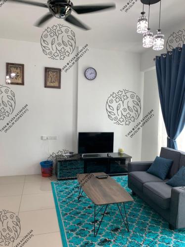 een woonkamer met een bank en een plafondventilator bij TIARA @ CASA KAYANGAN (MUSLIM HOMESTAY) in Ipoh