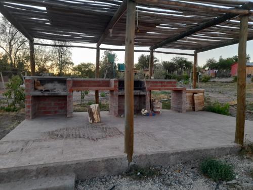 einen gemauerten Kamin unter einem Holzdach in der Unterkunft Domos y cabañas Monte Patria in Monte Patria