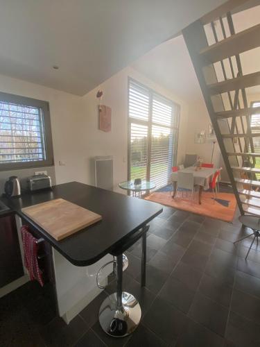 Il comprend une cuisine et un salon avec une table et un escalier. dans l'établissement Le Cube, à Nayemont-les-Fosses