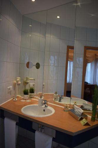 a bathroom with a sink and a large mirror at Fährhaus Farge Bremen in Bremen