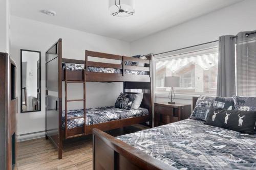 a bedroom with two bunk beds and a bed at 20- Chalet à louer à Stoneham (CITQ287685) in Stoneham